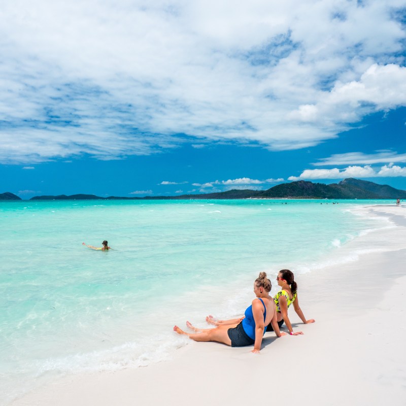 a group of people on a beach near a body of water