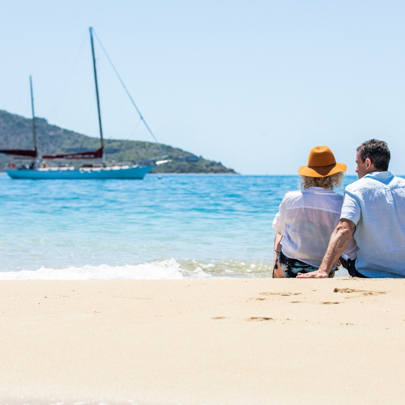 a person sitting on a beach near a body of water