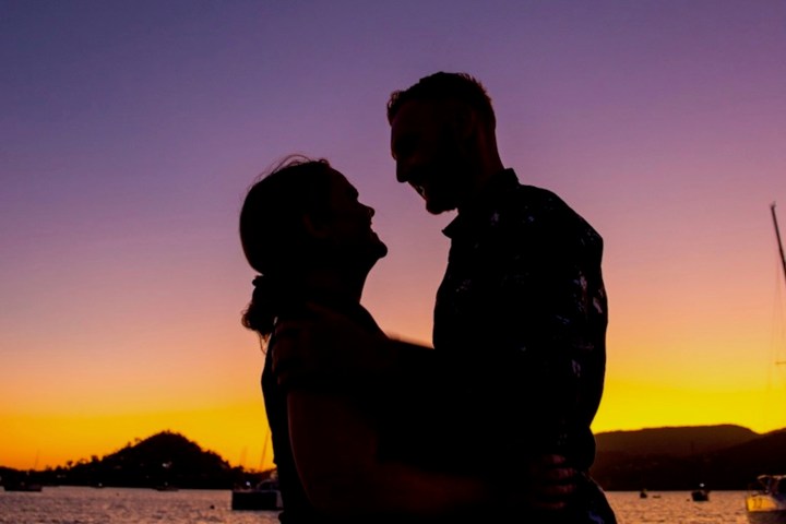 a man standing in front of a sunset