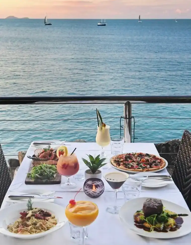 Soorento-Cruise-Dine-Sundowner-768×981 a person sitting at a table with food and water
