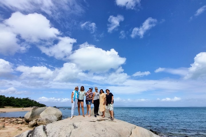a group of people on a beach near a body of water