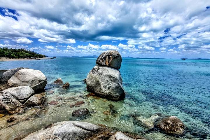a rocky island in the middle of a body of water